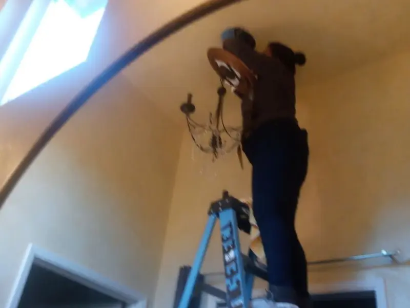 Electrician installing a chandelier in a Enumclaw residence